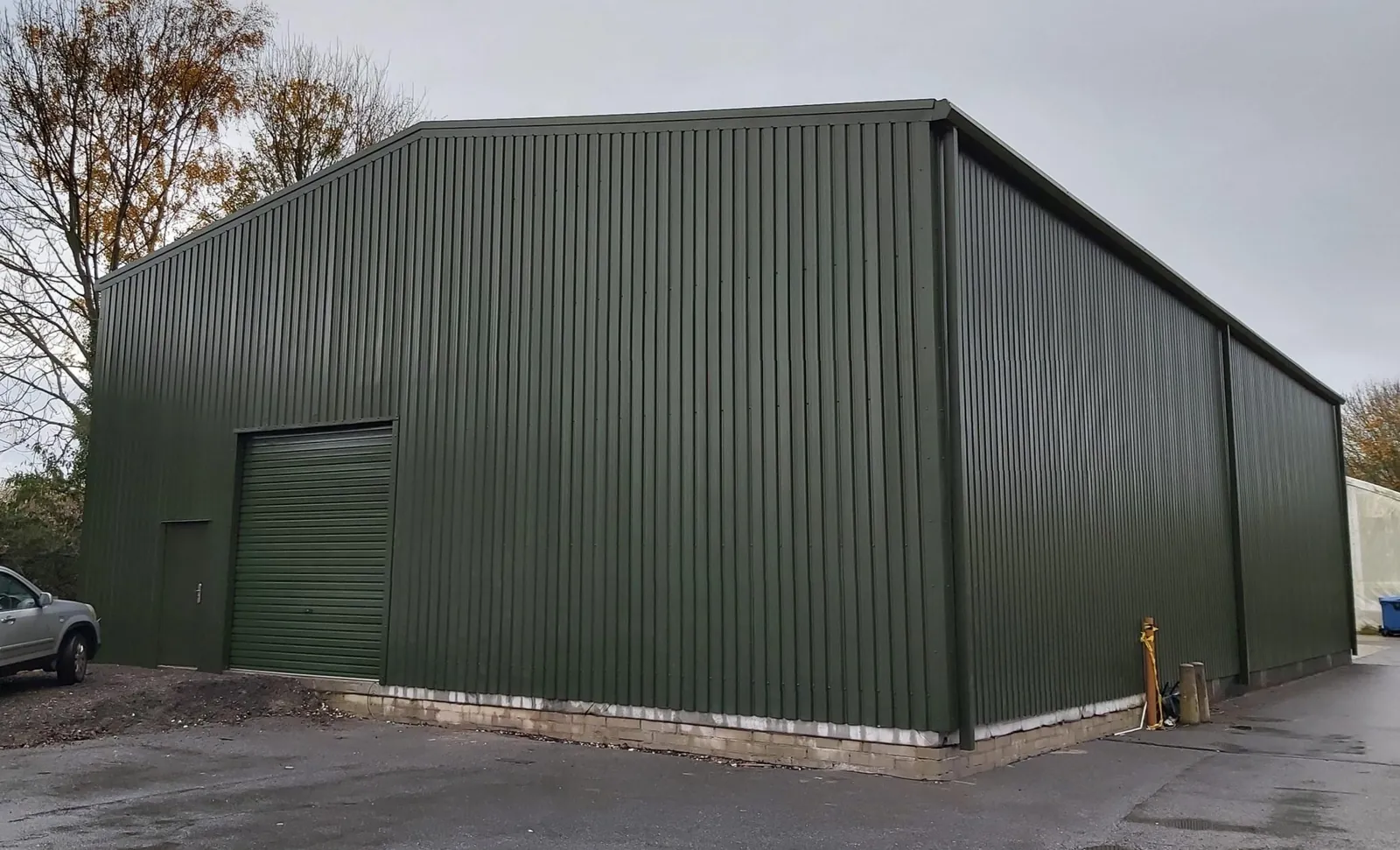 Large green clad steel building with a roller door